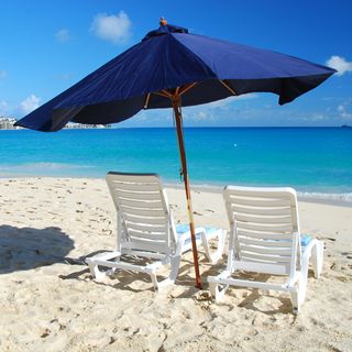seaside beach umbrella with beach white beach chair and sand