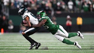 Quincy Williams #56 of the New York Jets tackles DeVonta Smith #6 of the Philadelphia Eagles during the second half at MetLife Stadium on October 15, 2023 