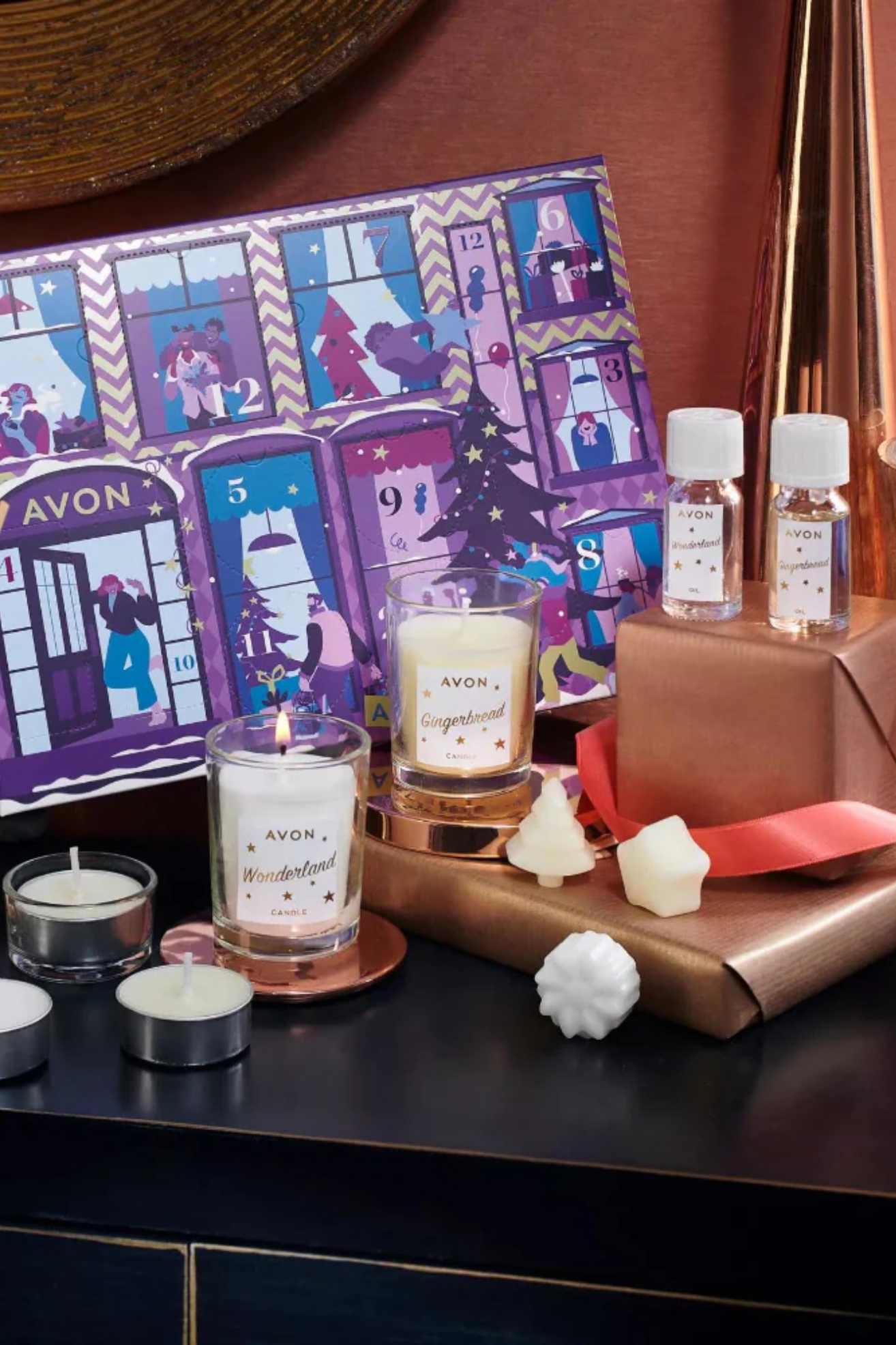 A purple advent calendar with essential oils, tealights, glass candles, wax tablets and more