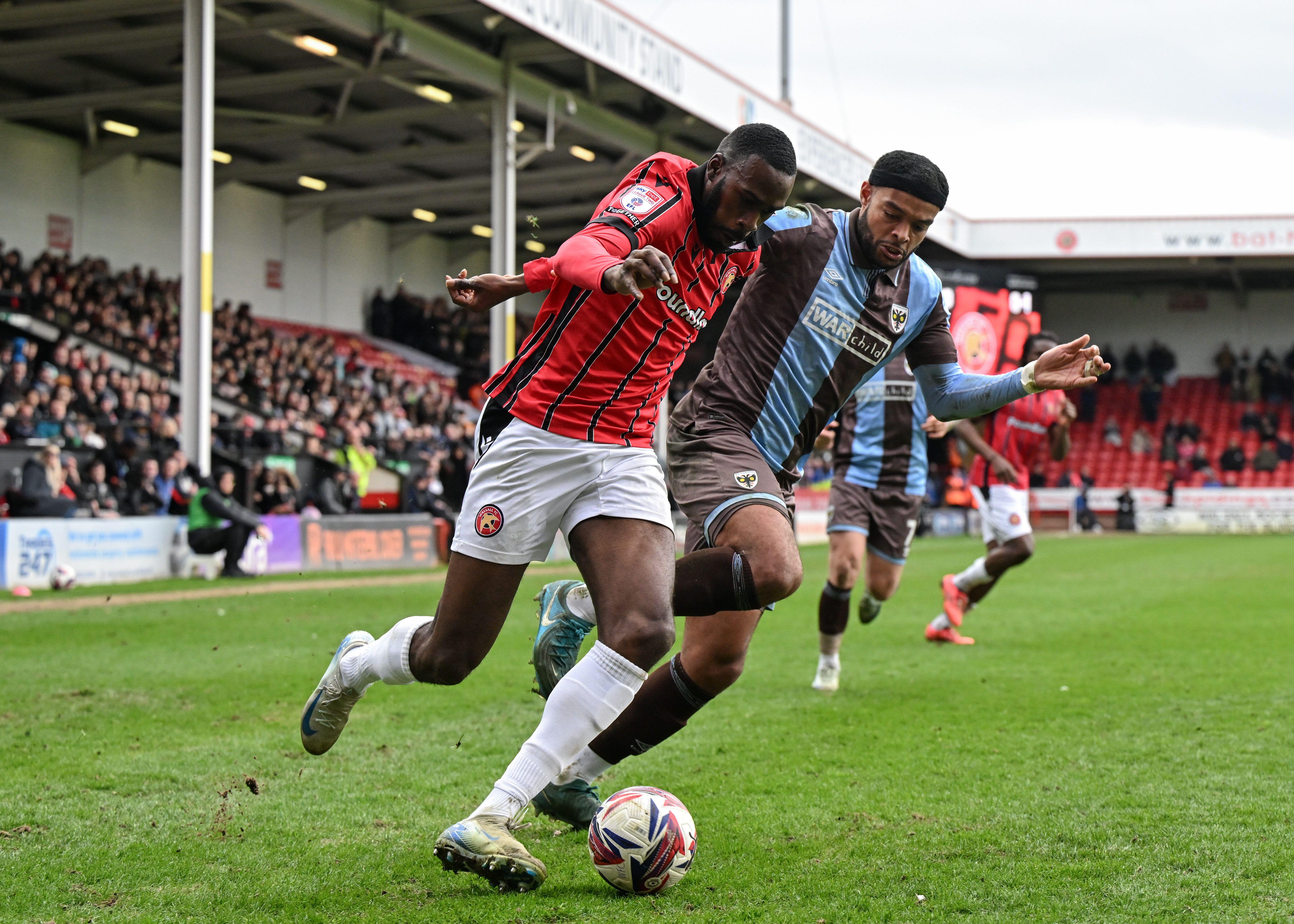 Walsall's Levi Amantchi and AFC Wimbledon's Ryan Johnson compete for the ball, March 2025