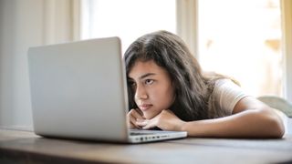Young woman using laptop and looking bored