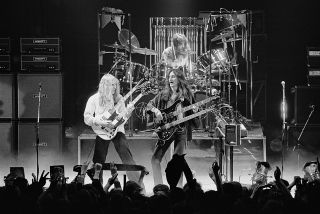 Double Vision: Alex Lifeson [left] onstage with the famous double-necked guitar