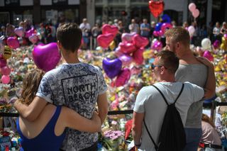 Crowds gather in front of tributes to the victims of therManchester Arena bombing