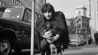 Cat Stevens holding a dog in the street in 1966