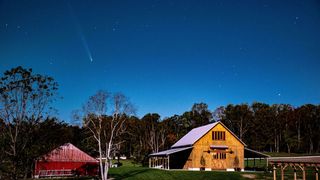 a streak of light above a barn