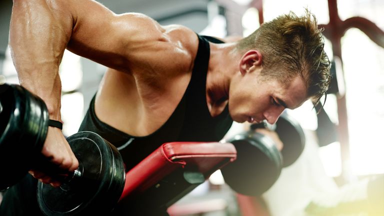 best dumbbells: Shot of a young man working out at the gym
