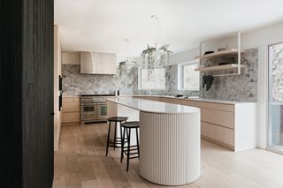 a kitchen with a round fluted island