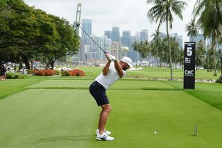 Dustin Johnson hitting a tee shot at a LIV Golf event