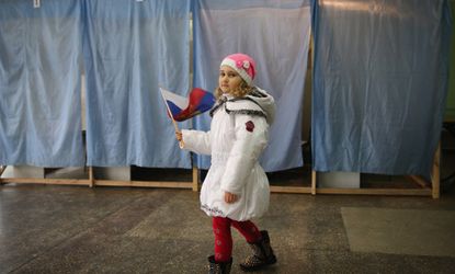 A girl stands outside a polling place in Crimea