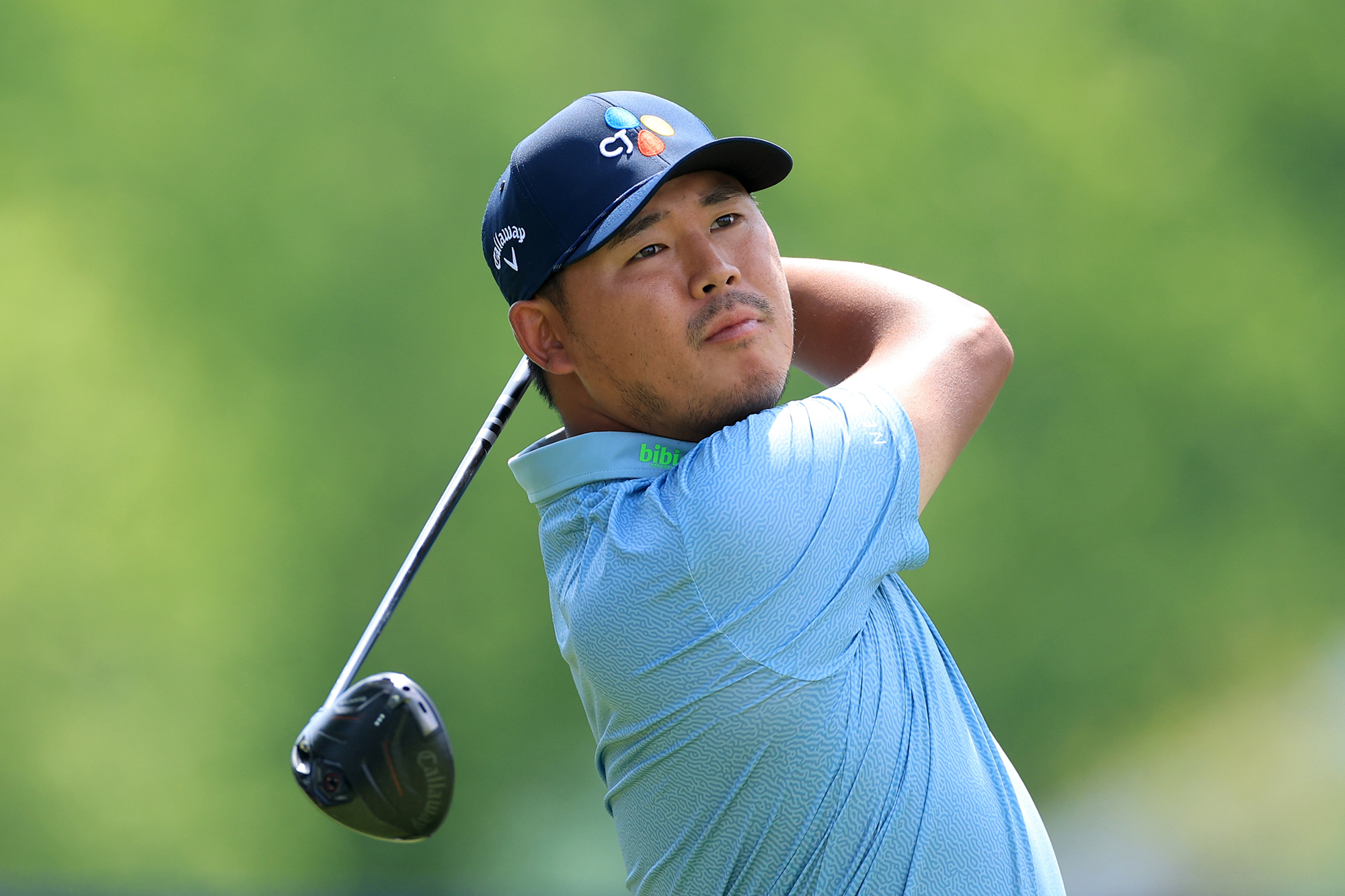 Si Woo Kim in the finish position after hitting a tee shot with driver