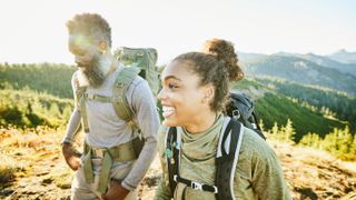 Smiling daughter and father on backpacking trip on fall afternoon