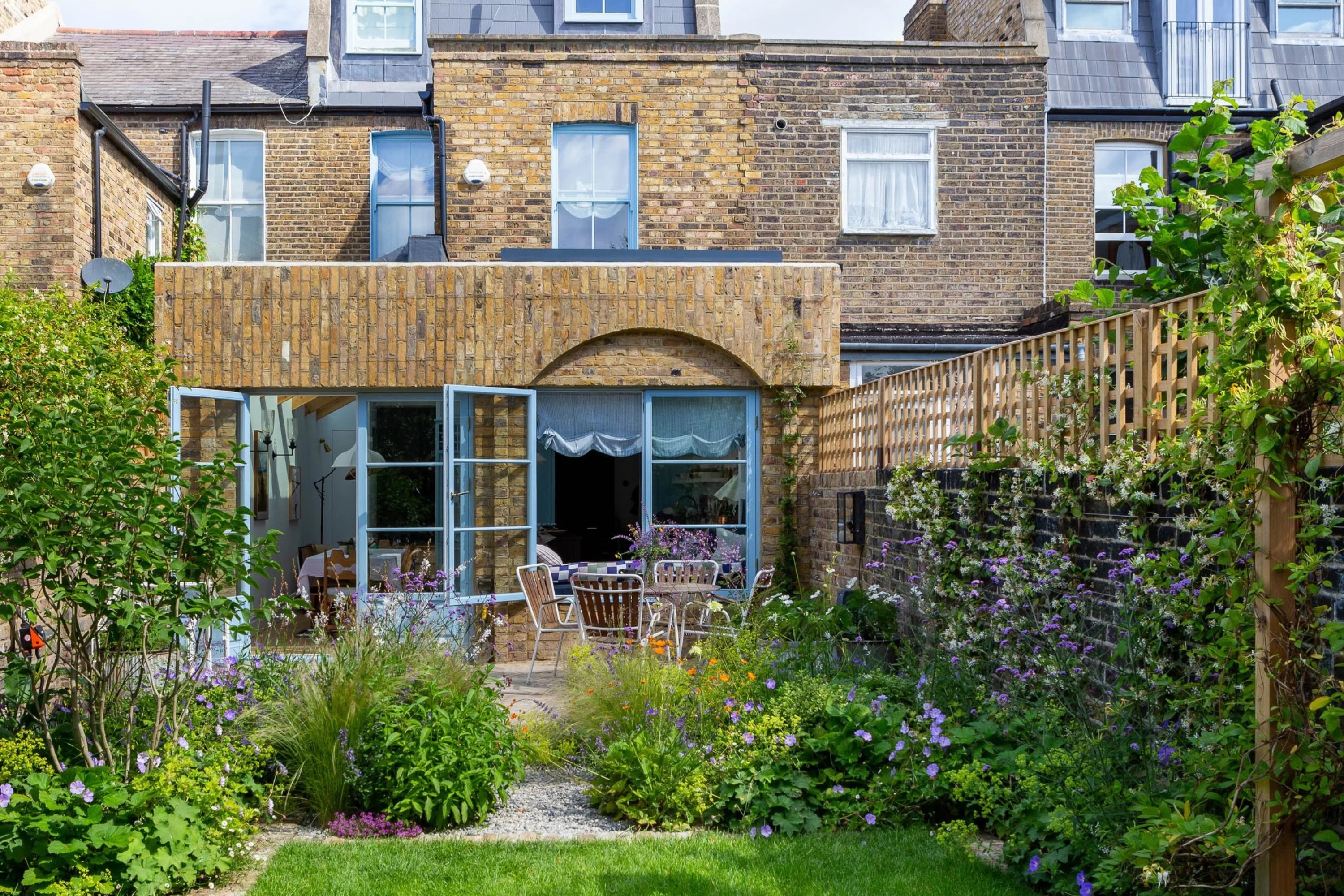 english garden with trellis on brick wall for privacy screening