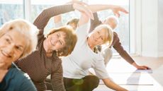 Group of active senior women exercise in yoga class.