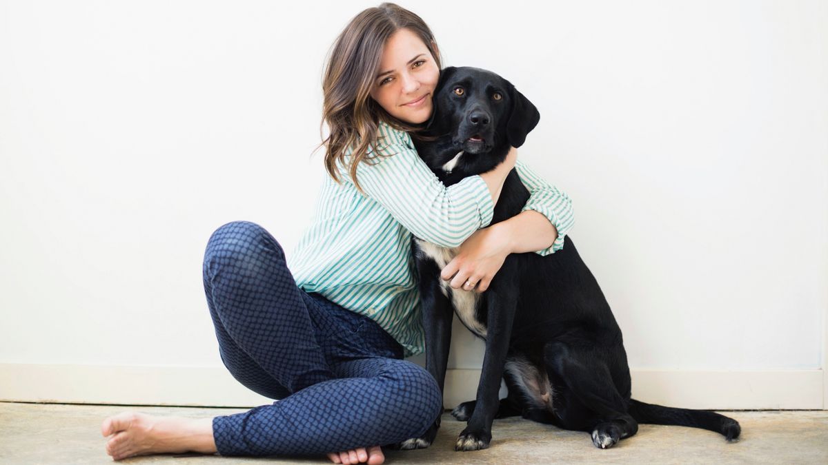 Woman hugging black dog