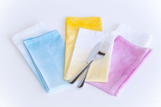 Pastel tie dye napkins with a knife and fork.