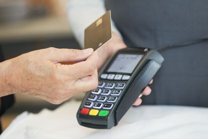 Close up of senior woman using contactless payment in shop