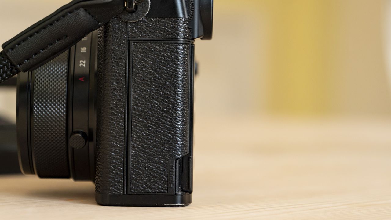 All-black Fujifilm GFX100RF rangefinder-style camera on a wooden table
