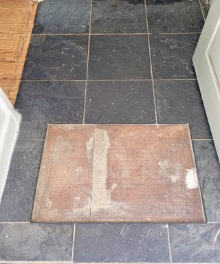 black slate floor tiles with a space for a front door mat