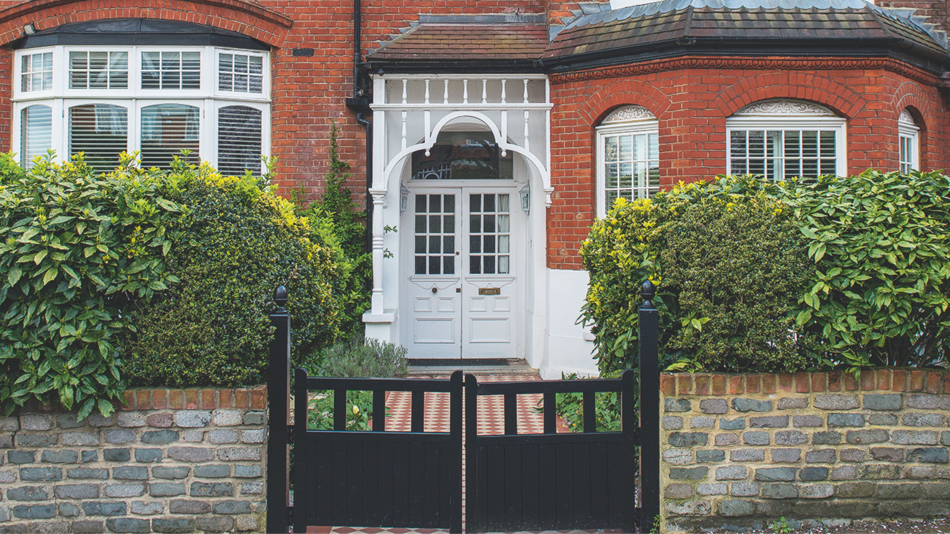 Red brick period house with front gate and path leading to the front door