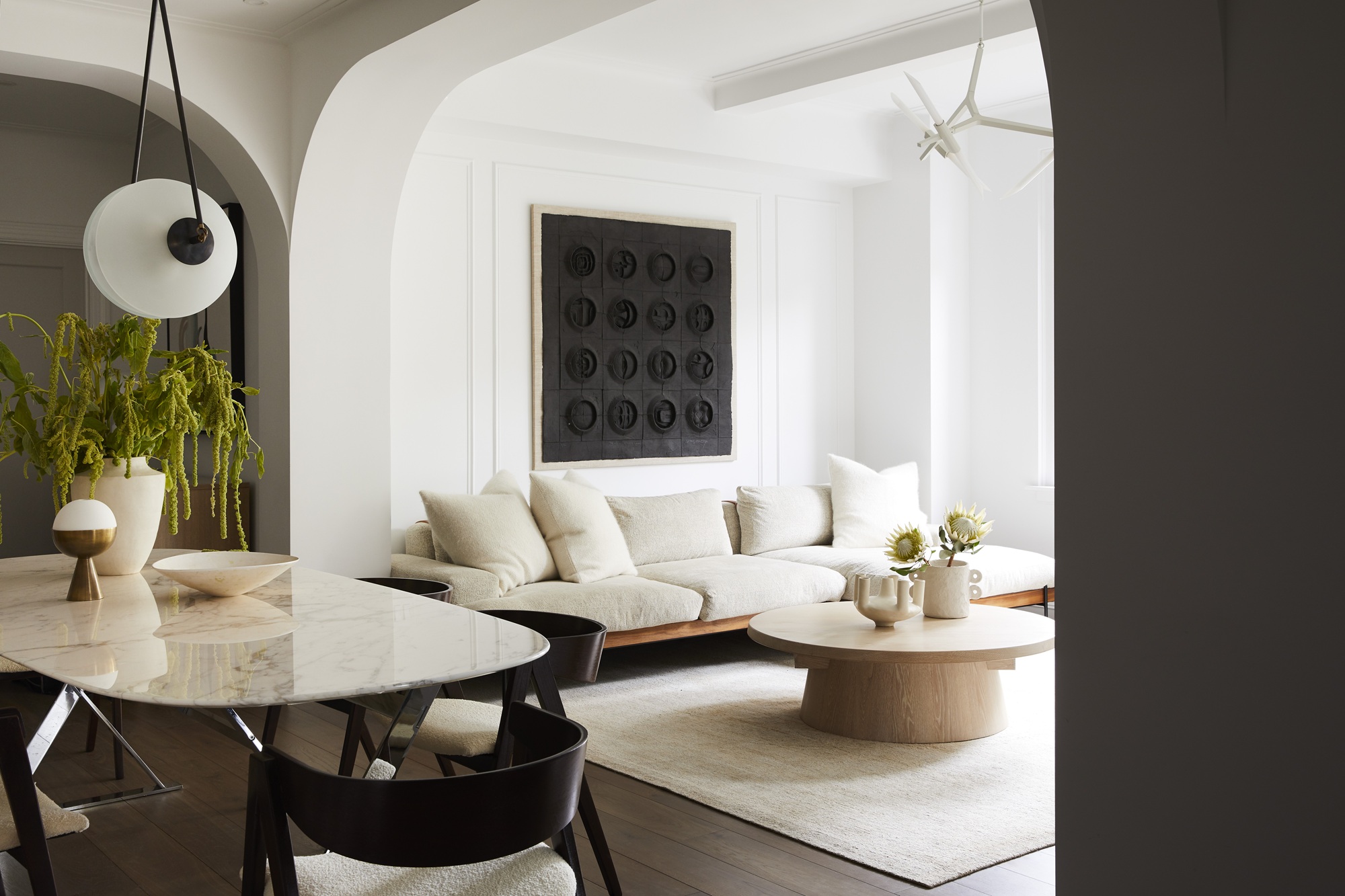 an apartment living and dining room with curved arches in the architecture