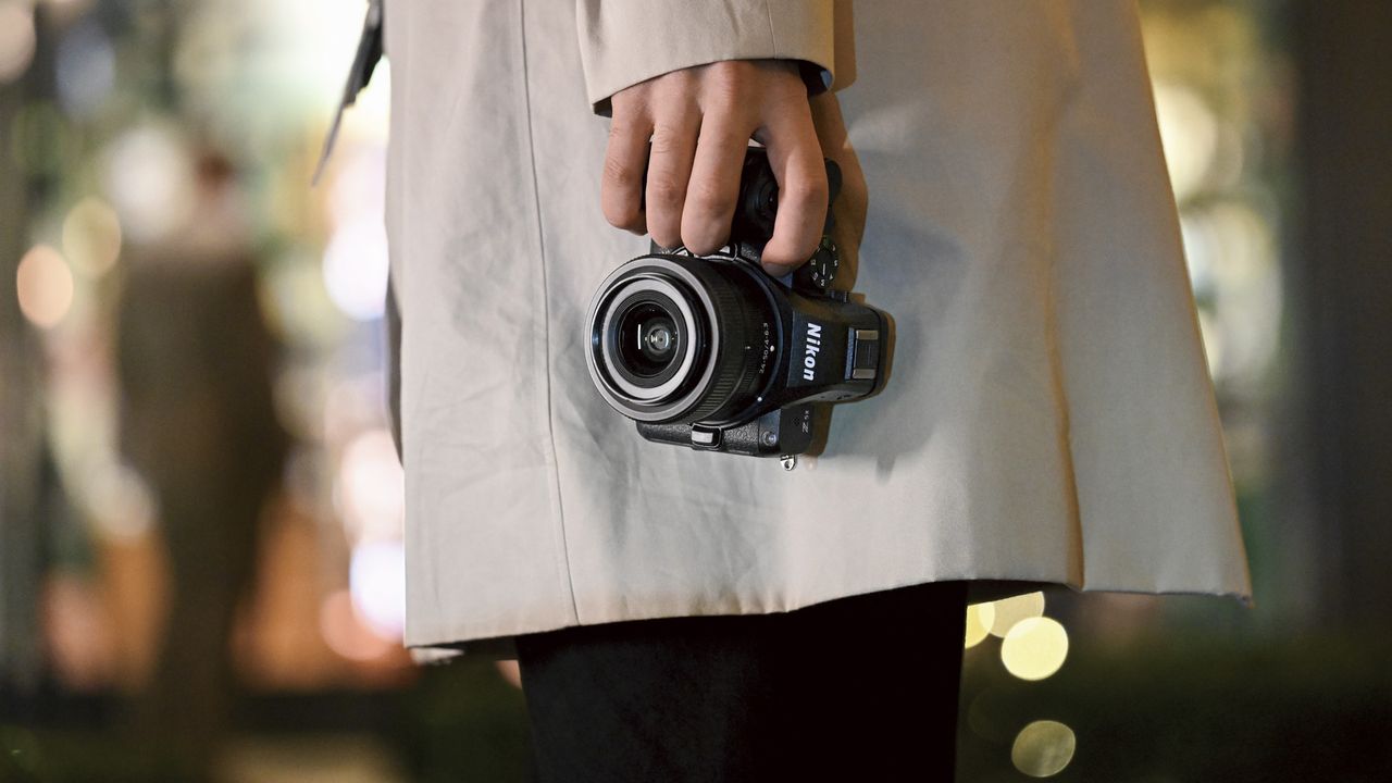 Nikon Z5 II camera in person's hand in the city at night