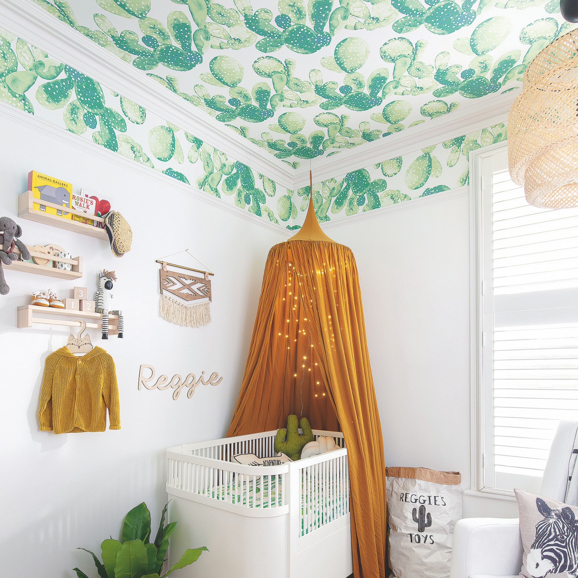 A child's bedroom with while walls and a green design on the ceiling