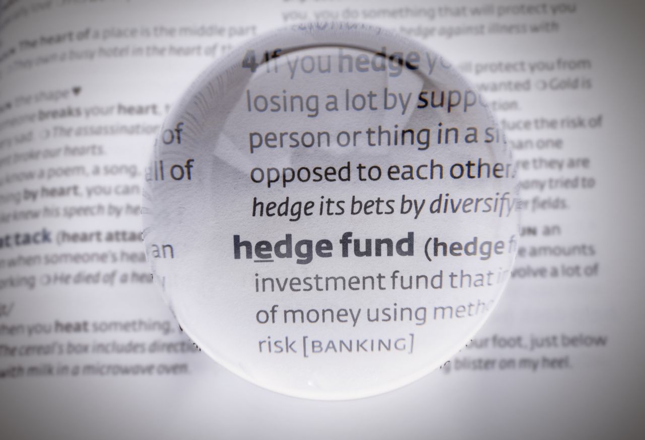 magnifying glass hovering over phrase &quot;hedge fund&quot; in dictionary