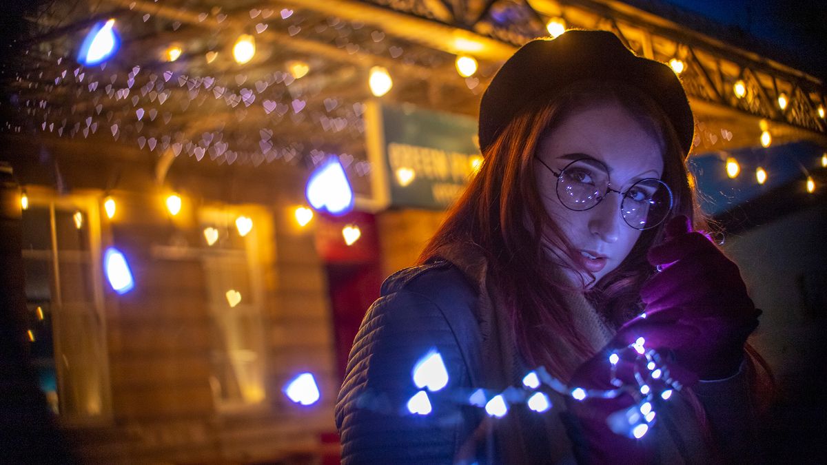 Portrait of model in low light, with surrounded by heart-shaped bokeh 