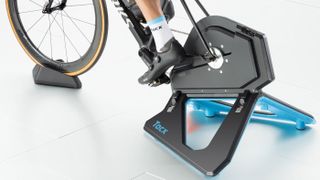 A man uses the Tacx Neo 2T Smart Trainer for indoor cycling training
