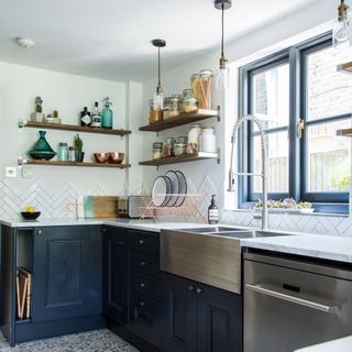 monochrome kitchen with black cabinets, white tiles and stainless steel sink