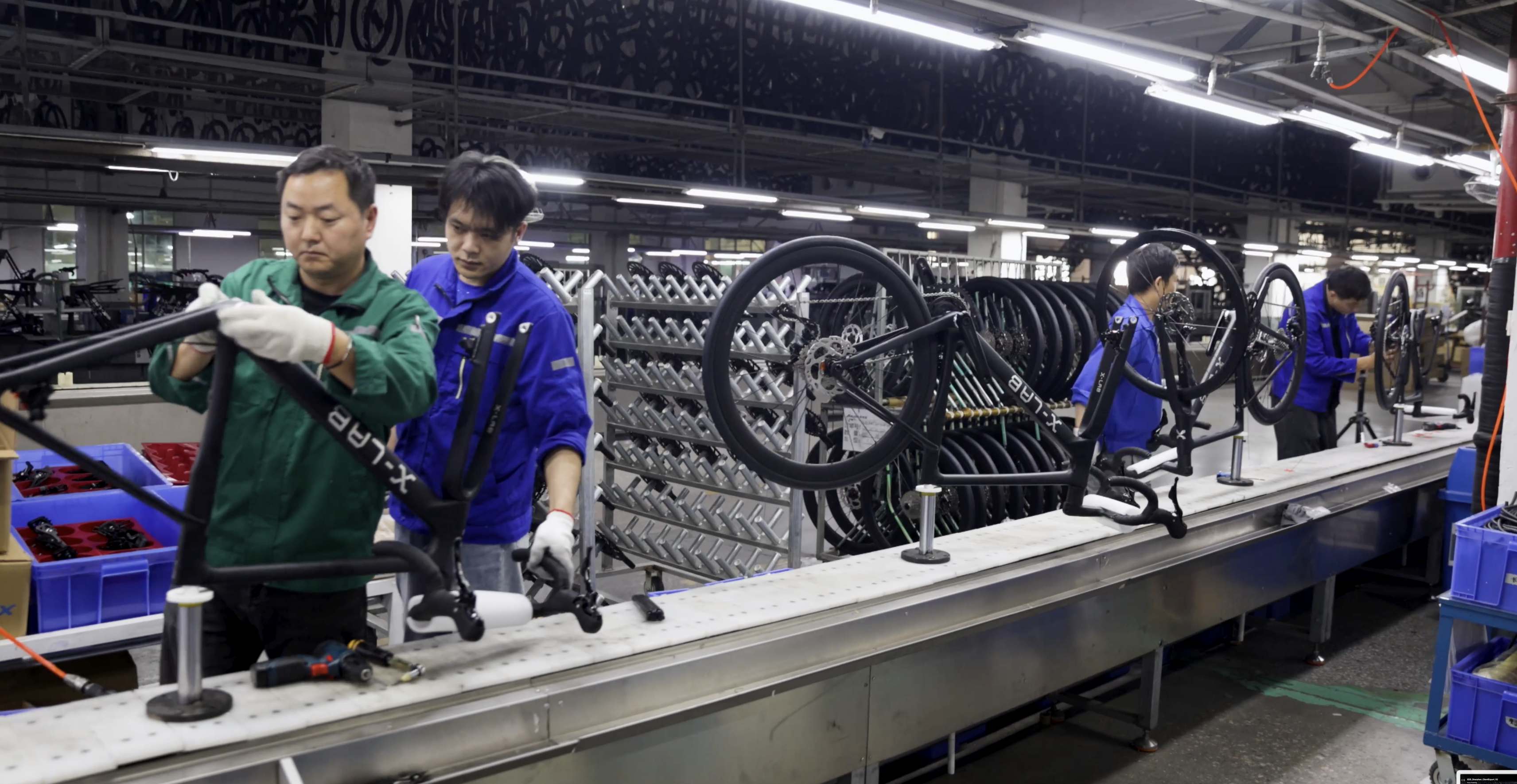 A CNC machine drilling a black carbon bike frame