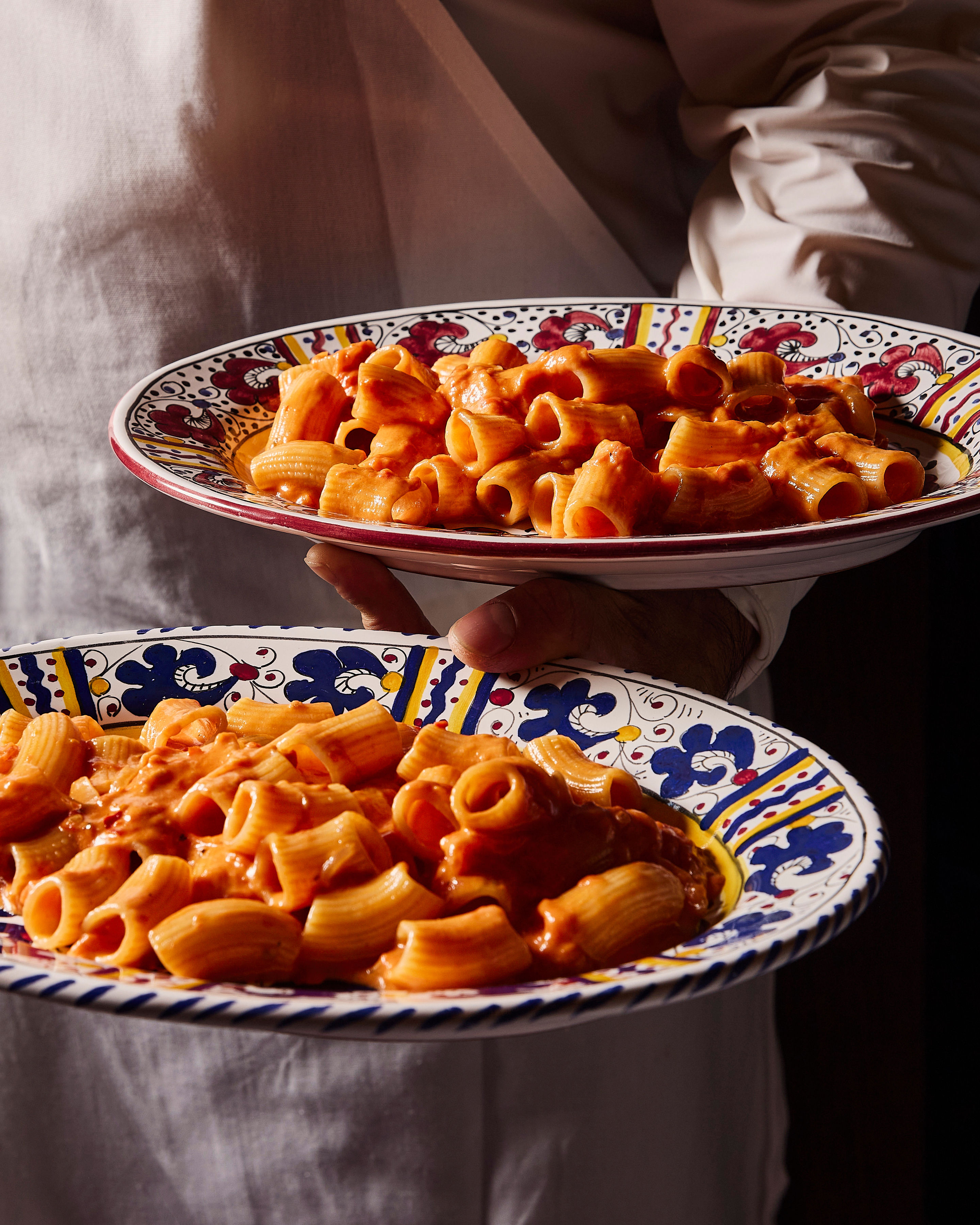 A series of lifestyle shots depicting eccentrically plated restaurant food, including pasta dishes, lemon and tiramisu cakes, fish, ice cream, and more, under a flashed-out cold light.