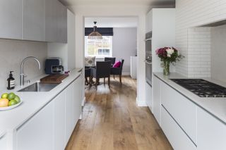 Kitchen with contemporary white cabinets and hardwood floor