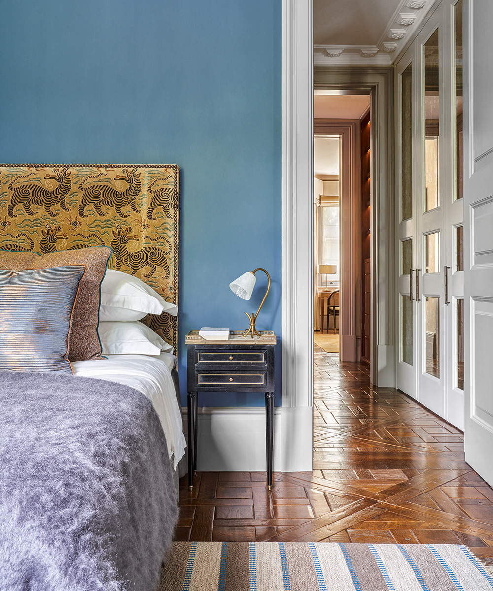 A bedroom with a wooden floor and blue walls