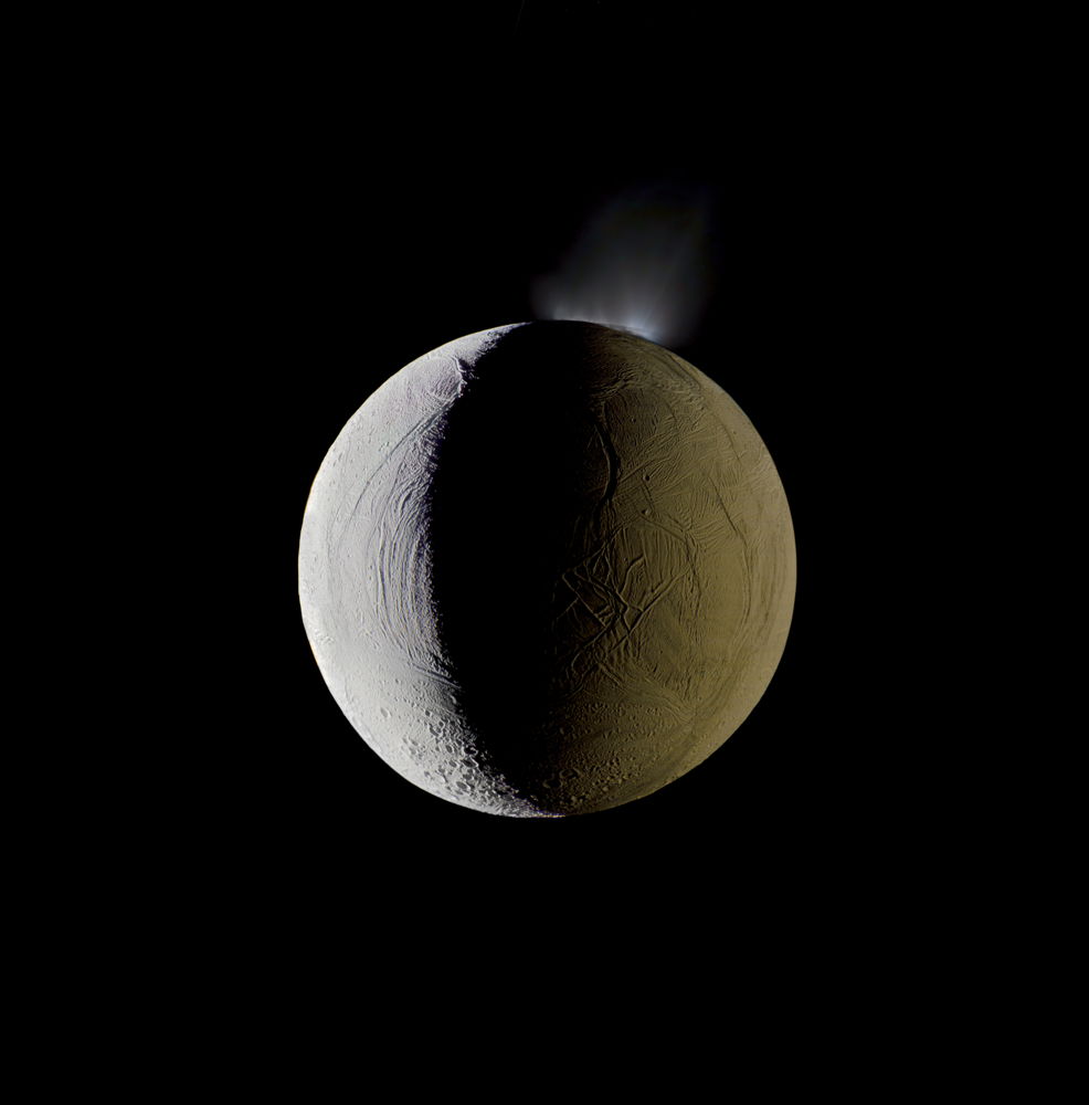 Enceladus vents water into space from its south polar region. The moon is lit by the Sun on the left, and backlit by the vast reflecting surface of its parent planet to the right. Icy crystals from these plumes are likely the source of Saturn's nebulous E ring, within which Enceladus orbits. Mosaic composite photograph. Cassini, December 25, 2009.