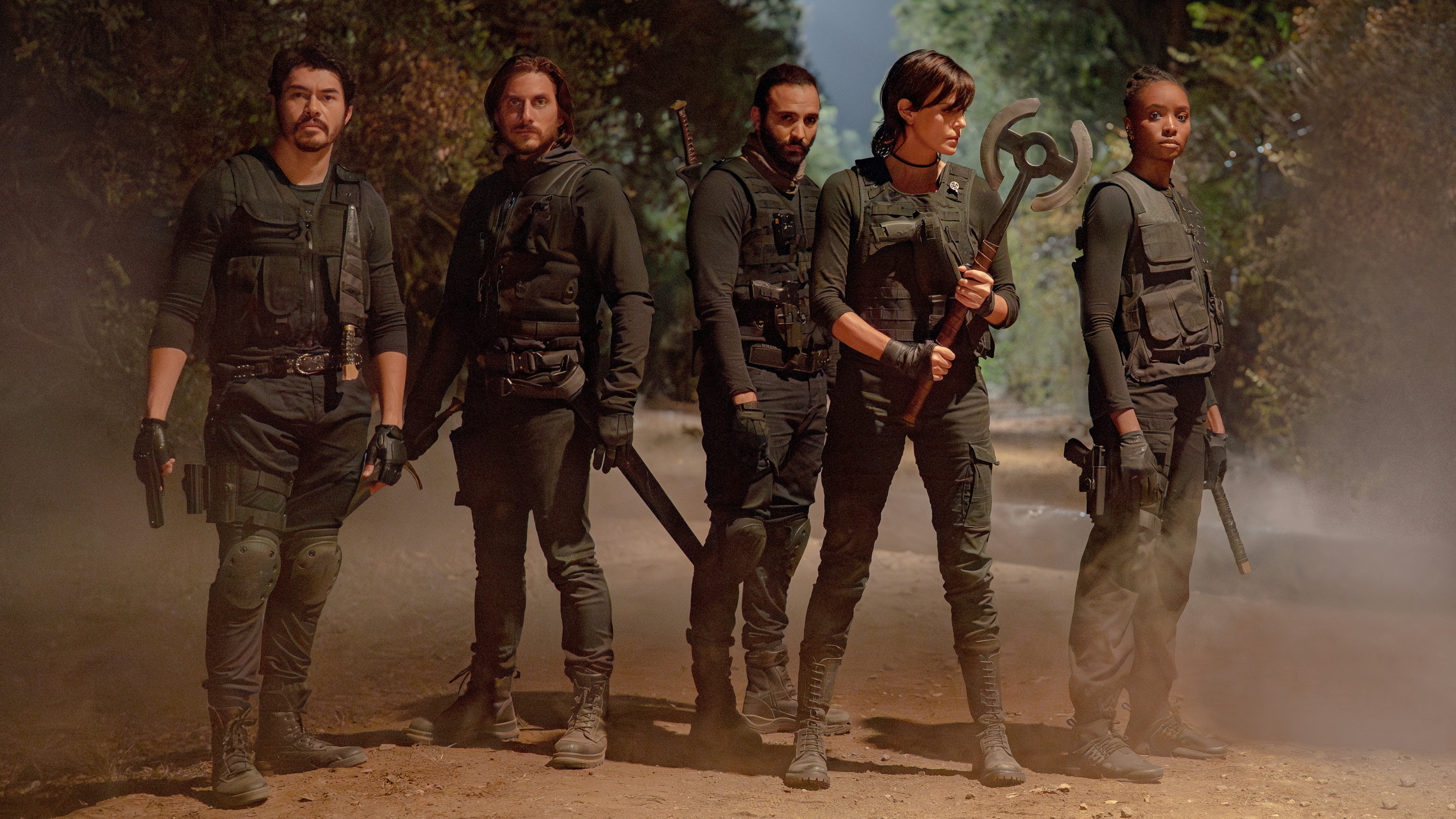 L-R: Tuah (Henry Golding), Nicky (Luca Marinelli), Joe (Marwan Kenzari), Andy (Charlize Theron), and Nile (KiKi Layne) in tactical gear stand ready for battle in Netflix's "The Old Guard 2"