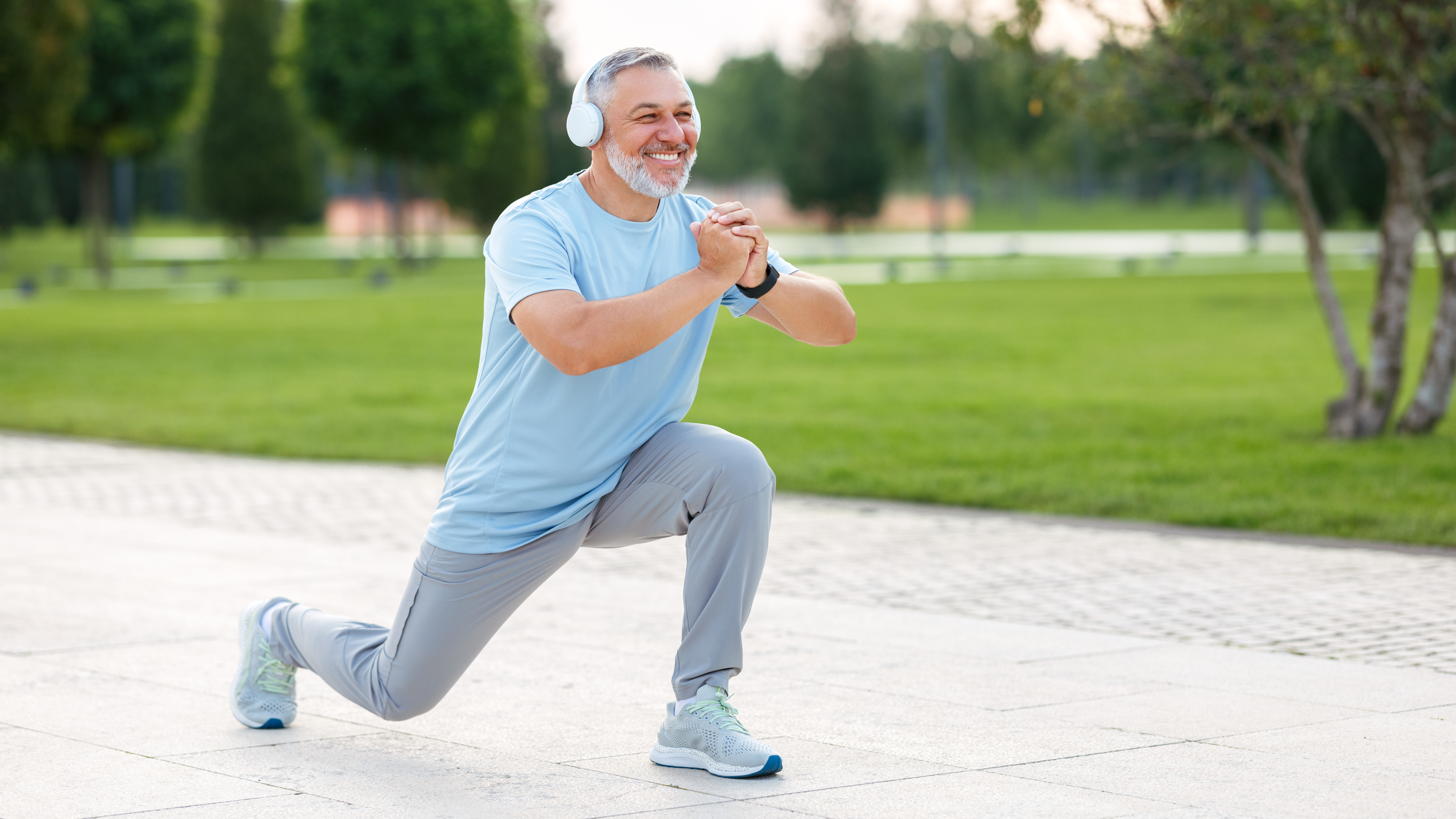 a man with headphones on outside doing a lunge