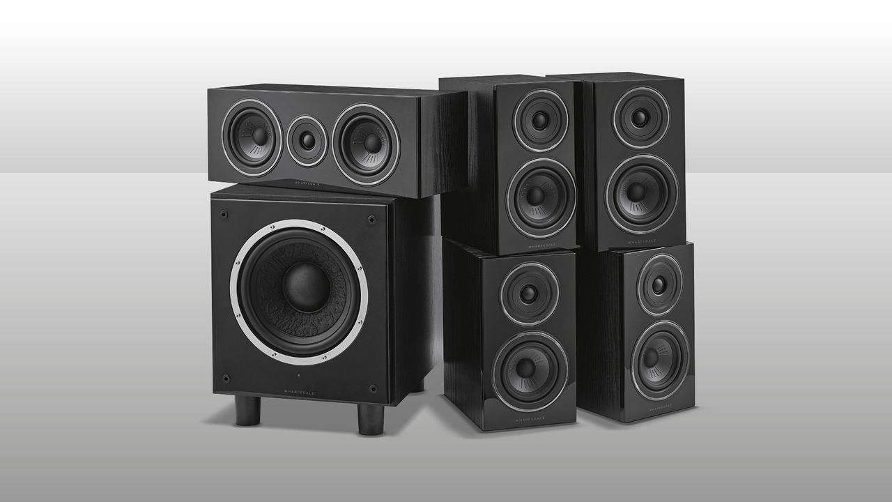 A picture of the Wharfedale Diamond 12.1 HCP speaker system. It shows a square subwoofer on the left with another speaker positioned on top, with the other four speakers arranged to the right. They are all black on a grey background.