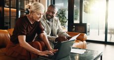 Mature couple, laptop and smile with paperwork in home for mortgage, bills or investment. Mature man, woman and document with tech for financial planning, budget expenses or invoices together
