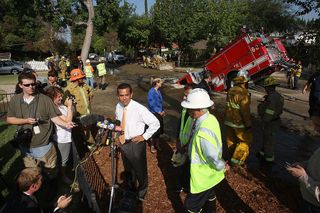 Los Angeles mayor Antonio Villaraigosa talks to reporters near a 22-ton Los Angeles Fire Department fire truck protruding from a sinkhole on September 8, 2009 in the Valley Village neighborhood of Los Angeles, California.
