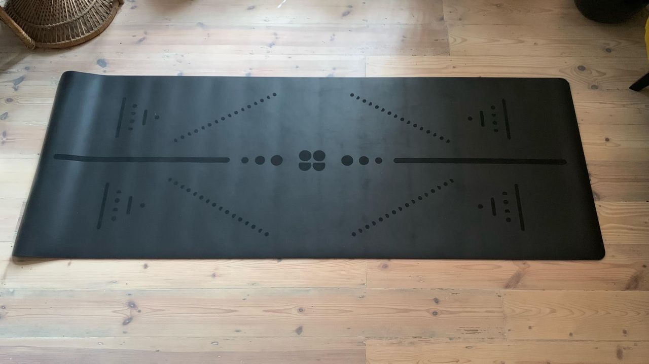 Lululemon workout mat rolled out on a clean wooden floor