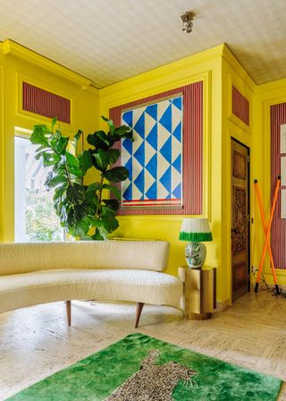 Yellow neon walls, green leopard rug, cream rounded sofa