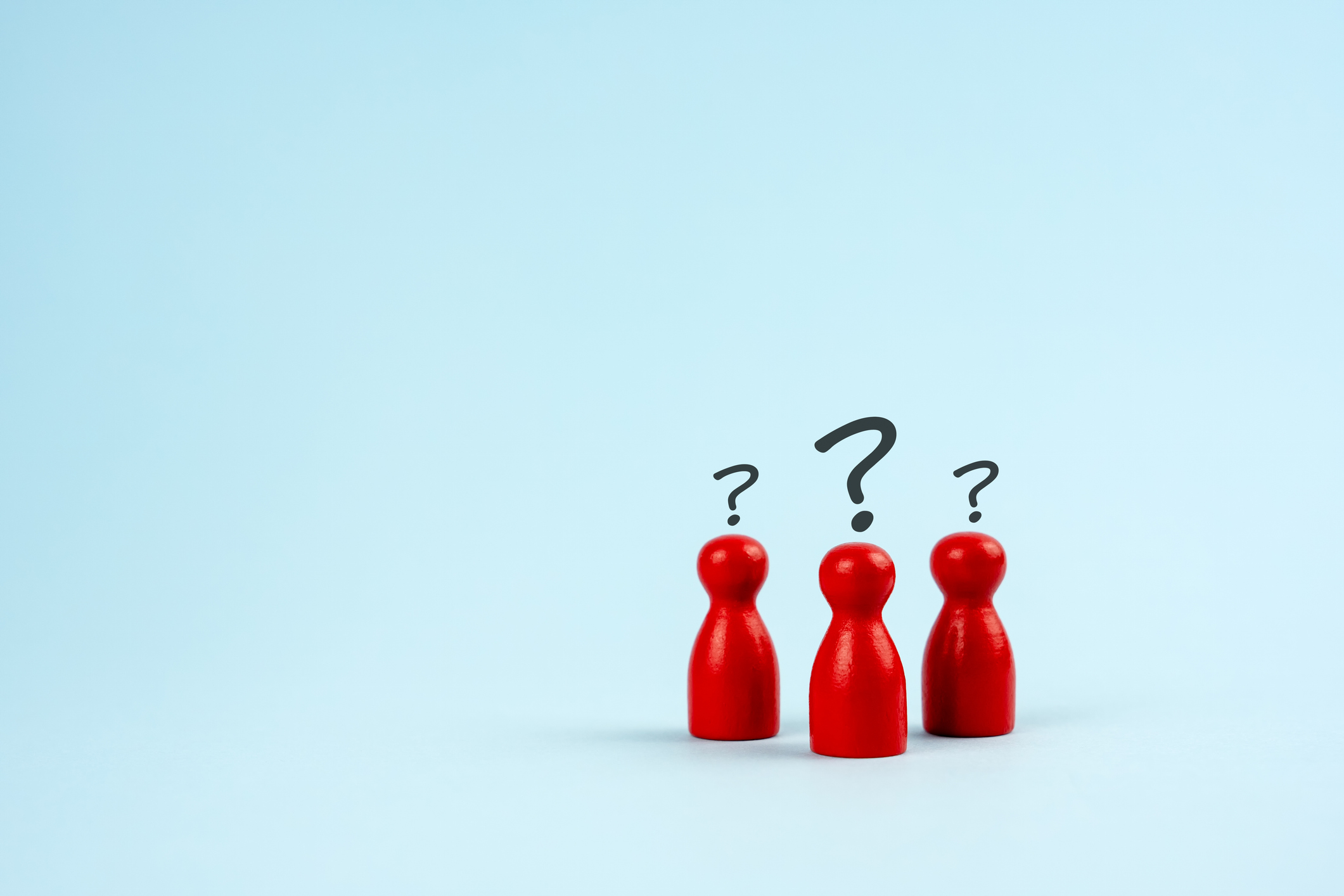 red wooden peg people with black questions marks over their heads
