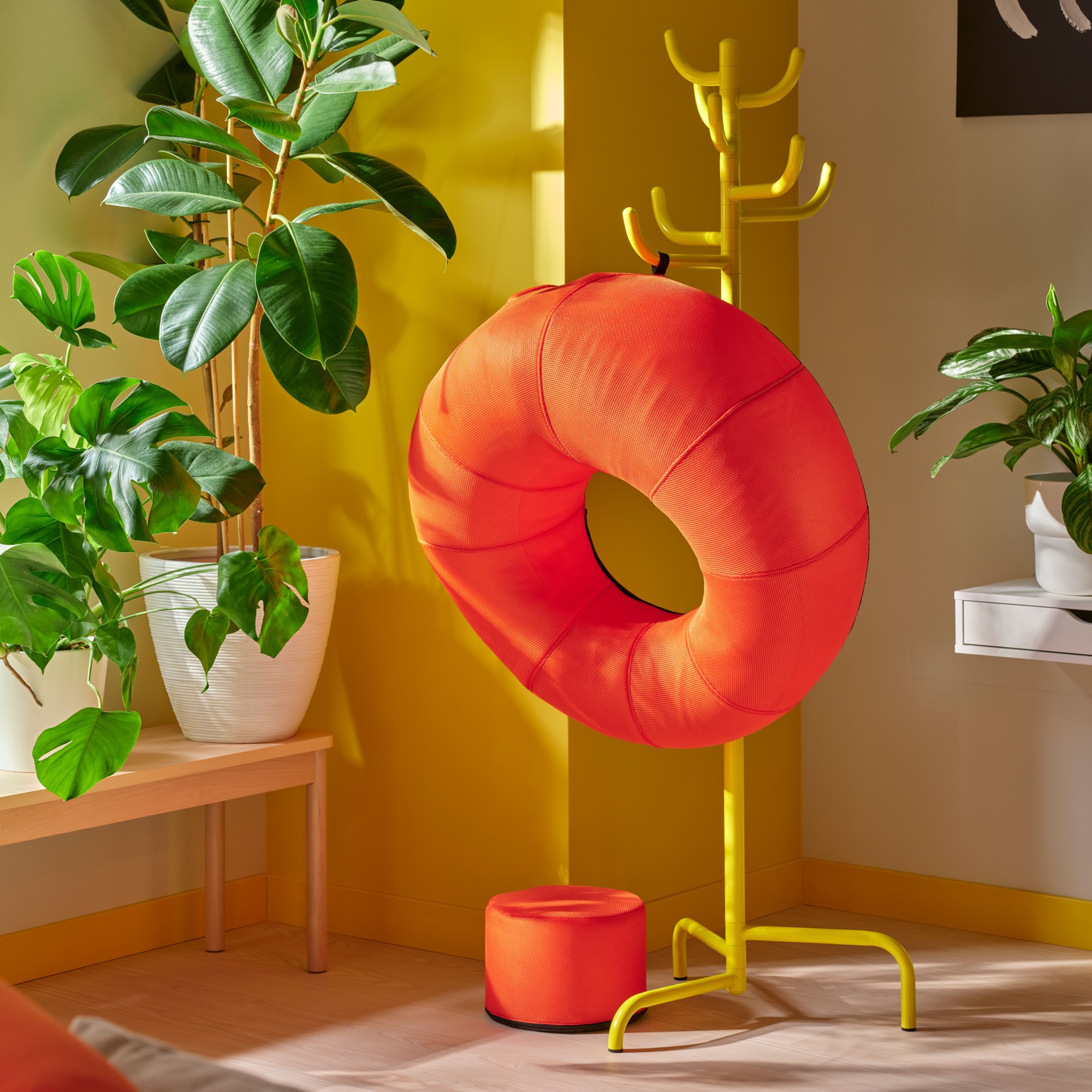 IKEA BRÄNNBOLL collection inflatable chair hanging on a rail in a yellow room