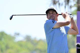 Keegan Bradley hits his tee shot and watches it in the air