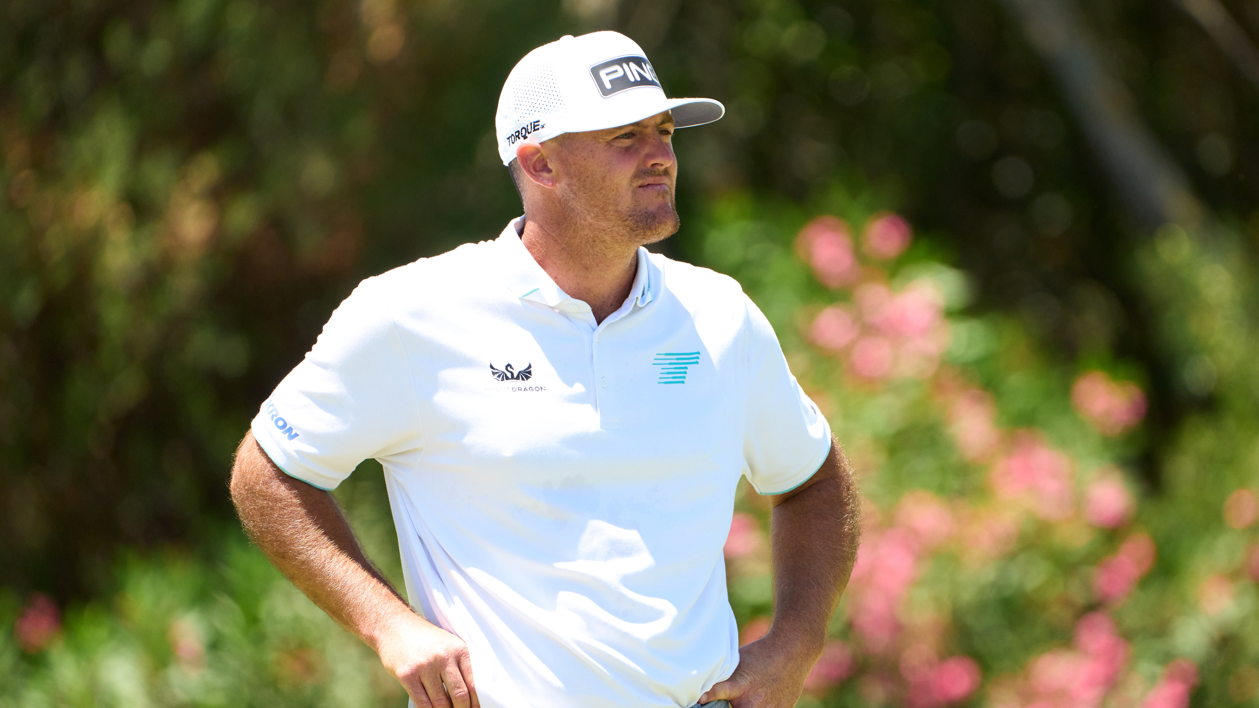 Mito Pereira looks on during a LIV Golf event wearing a white polo and white Ping cap