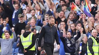 Graham Potter looks dejected as Brighton fans celebrate during their 4-1 win over Chelsea at the Amex.