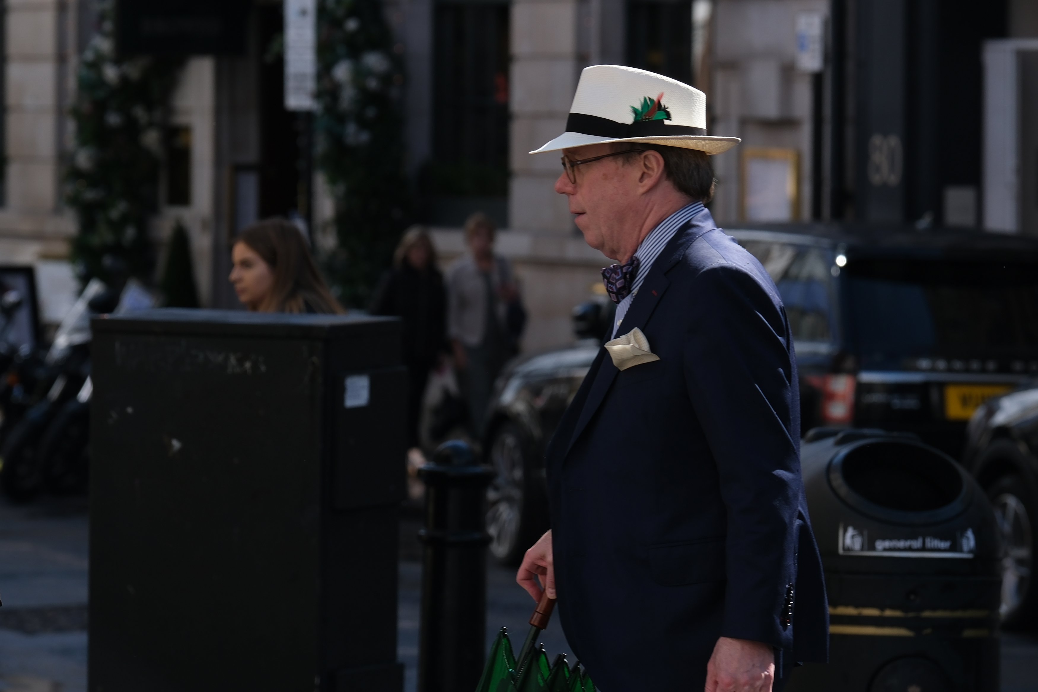 A man in a hat walking through a London street