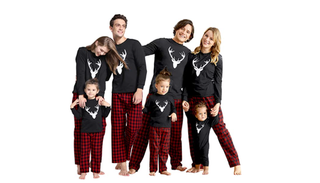 A family stands in matching red, black and white PJs.