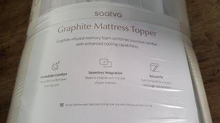 Saatva graphite mattress topper, wrapped in plastic after being delivered